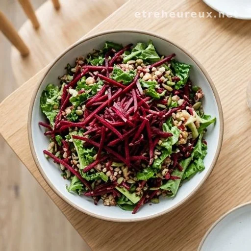Overhead view of a salad bowl with shredded raw beets and leafy greens